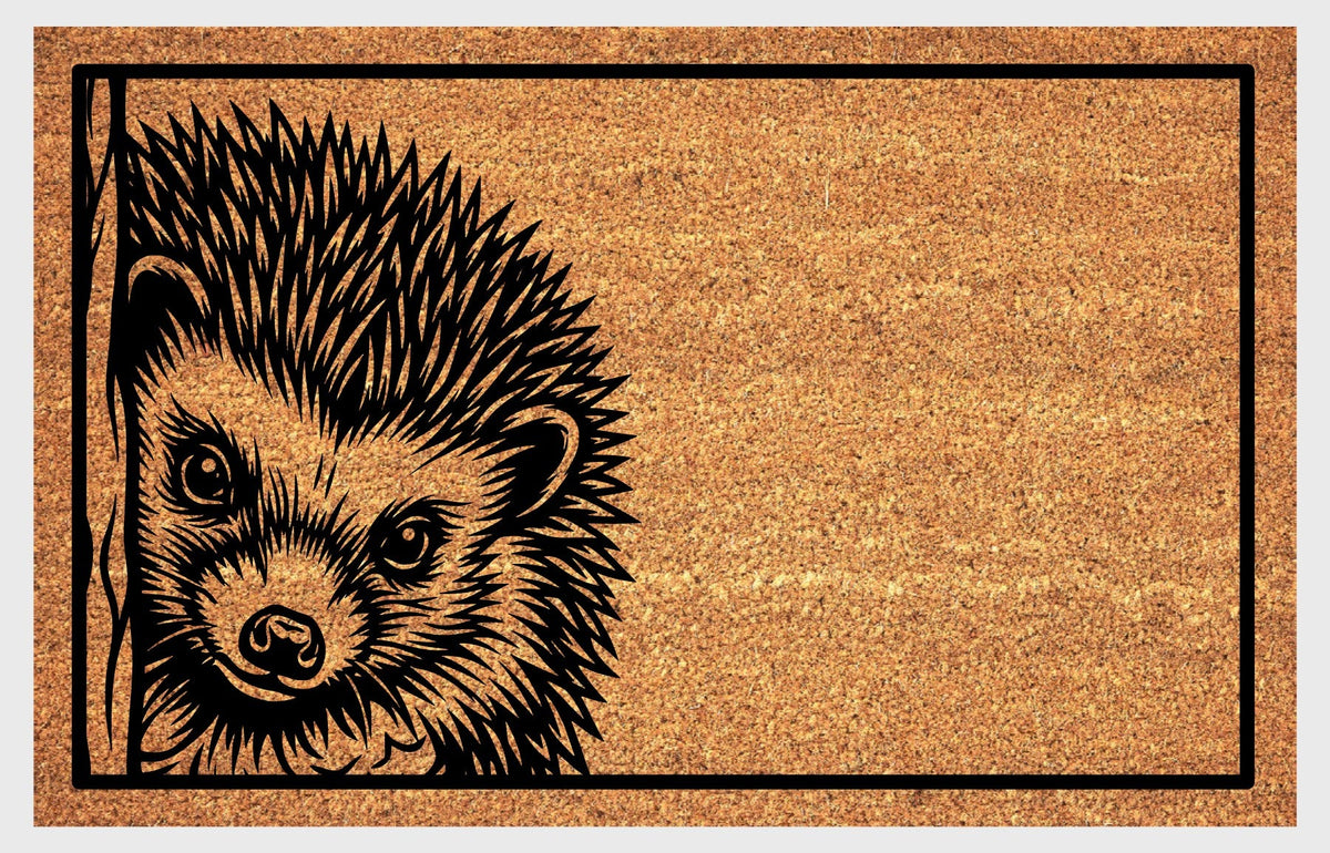 Hedgehog peeking coir doormat, front view showing a pointed nose, rounded ears and detailed spines inside a black rectangular border.