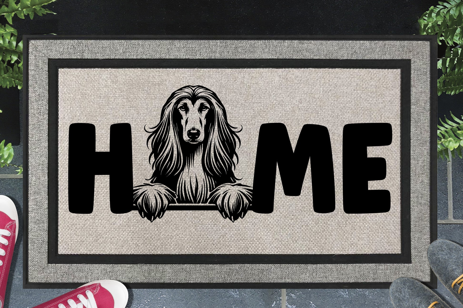 Afghan Hound all-weather doormat with portrait illustration of an Affie replacing the letter O in bold black HOME lettering, with flowing fur and feathered paws visible, on a light grey woven polyester surface with black border, plain white background