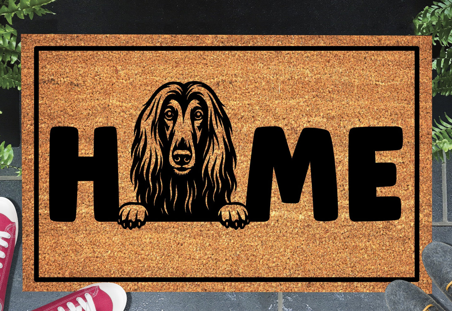Afghan Hound coir doormat with portrait illustration of an Affie replacing the letter O in bold black HOME lettering, on a natural golden coir surface with black border, styled on a slate doorstep.