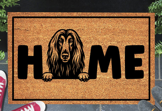 Afghan Hound coir doormat with portrait illustration of an Affie replacing the letter O in bold black HOME lettering, on a natural golden coir surface with black border, styled on a slate doorstep.