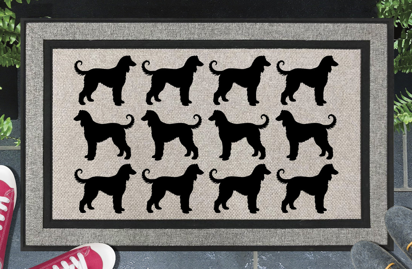 Afghan Hound Parade all-weather doormat in a doorway setting — rows of Afghan Hound silhouettes with flowing coat, long elegant neck, and curled tail in a repeating pattern on a woven polyester mat with black border