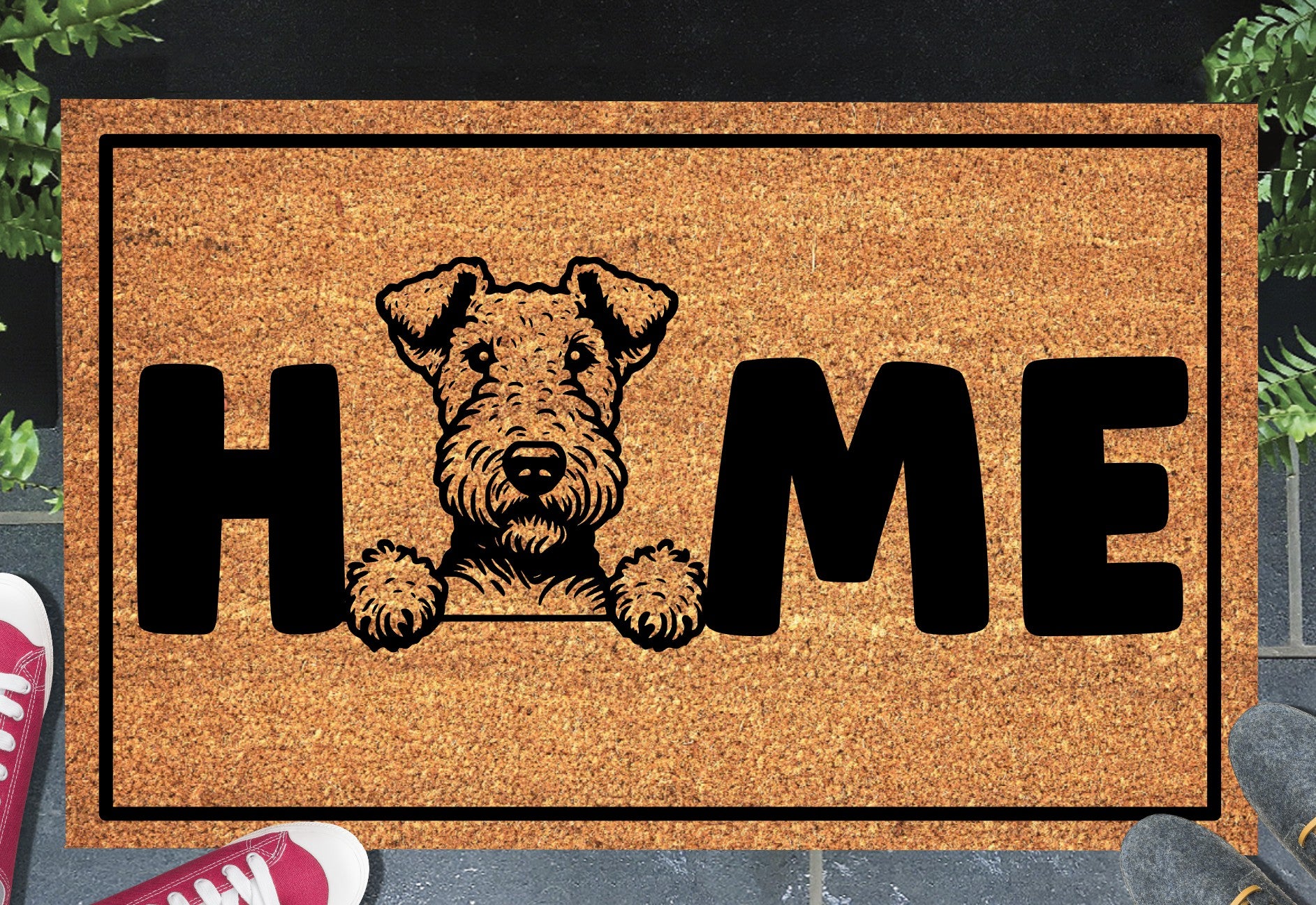 Airedale Terrier coir doormat with portrait illustration of an Airedale Terrier replacing the letter O in bold black HOME lettering, on a natural golden coir surface with black border, styled on a slate doorstep.
