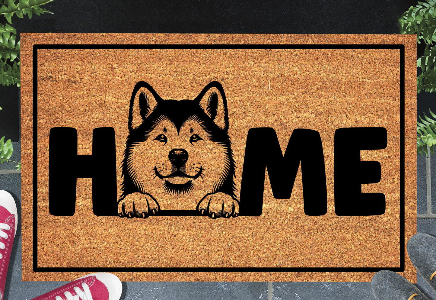 Akita coir doormat with portrait illustration of an Akita replacing the letter O in bold black HOME lettering, on a natural golden coir surface with black border, styled on a slate doorstep.