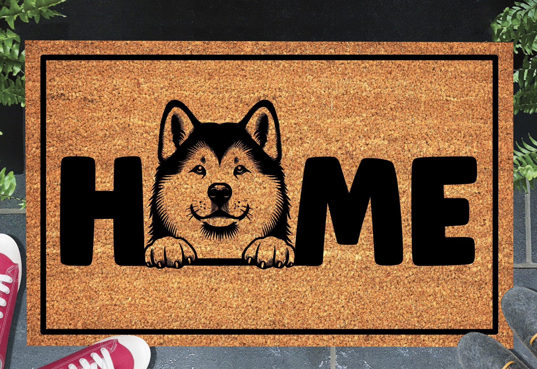 Akita coir doormat with portrait illustration of an Akita replacing the letter O in bold black HOME lettering, on a natural golden coir surface with black border, styled on a slate doorstep.