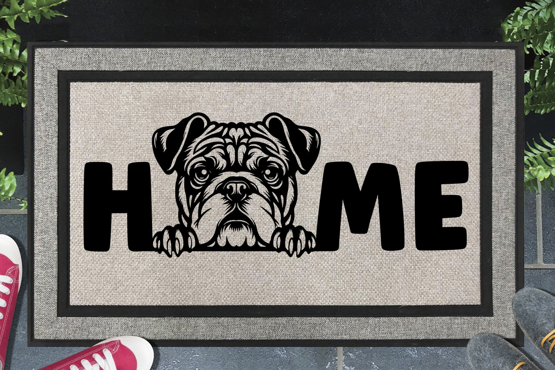 American Bulldog HOME all-weather doormat in doorway lifestyle shot — light grey linen-look woven polyester mat, broad wrinkle-faced American Bulldog head and paws illustration replaces the letter O in HOME, 18x30 size shown