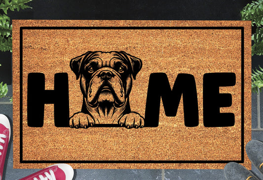 American Bulldog HOME doormat in doorway lifestyle shot — natural tan coir mat, American Bulldog head and paws illustration replaces the letter O in HOME