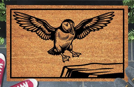 Atlantic Puffin coir doormat in a doorway — scenic illustration of Puffin coming in to land, wings raised, on a clifftop ledge, on natural coir