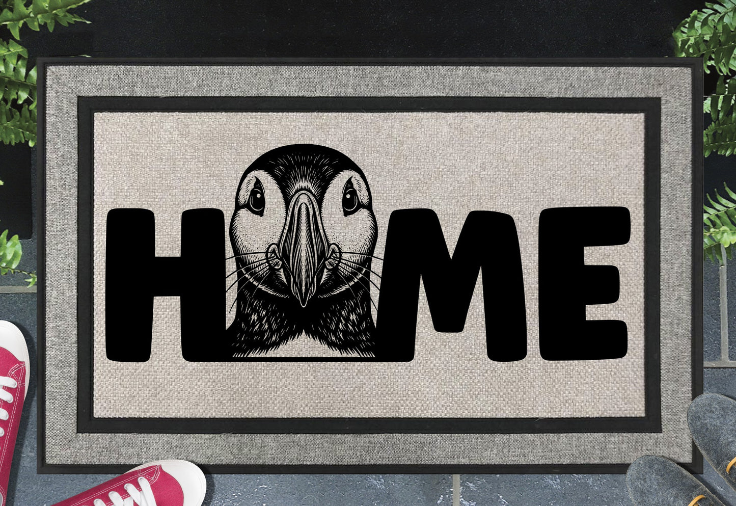 Atlantic Puffin all-weather doormat flat lay — Puffin illustration replacing the letter O in "HOME" on woven polyester with linen look finish