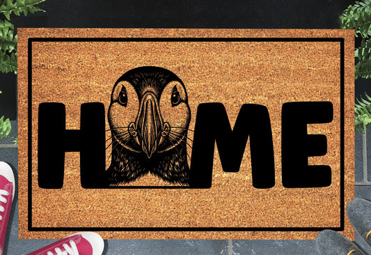 Atlantic Puffin coir doormat in a doorway — Puffin illustration replacing the letter O in "HOME" on natural coir