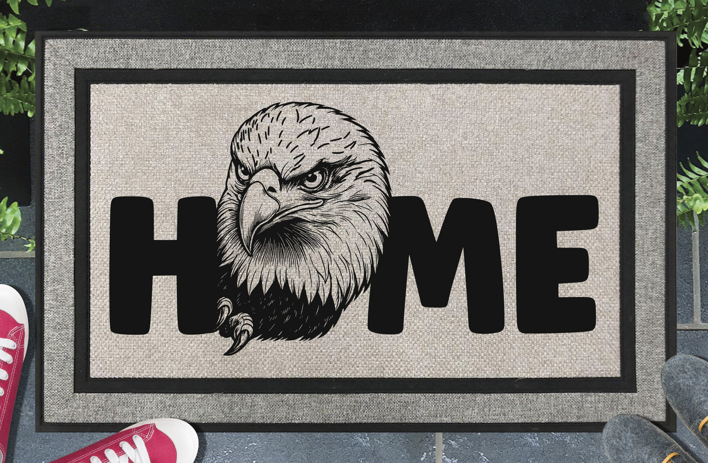 American Bald Eagle HOME all-weather doormat in doorway lifestyle shot — light grey linen-look woven polyester mat, large angled Bald Eagle head and talon illustration replaces the letter O in HOME, 18x30 size shown