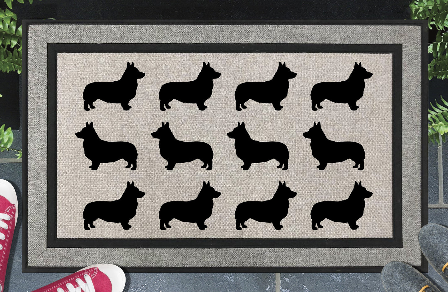 Corgi Parade all-weather doormat in a doorway setting — rows of Corgi silhouettes with low-slung body, perky ears, and sturdy frame in a repeating pattern on a woven polyester mat with black border