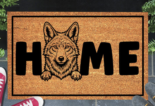Coyote Doormat #4 shown on a front doorstep — fourth alternate portrait-style coyote illustration with HOME lettering on a natural coir mat with black border