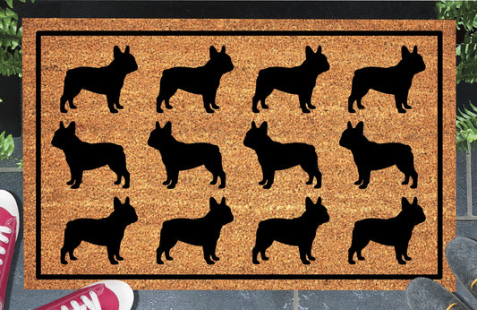 French Bulldog Parade coir doormat in a doorway setting — rows of Frenchie silhouettes in a repeating pattern on a natural coir mat with black border