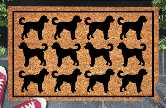 Goldendoodle Parade coir doormat in a doorway setting — rows of Doodle silhouettes with curly tails in a repeating pattern on a natural coir mat with black border
