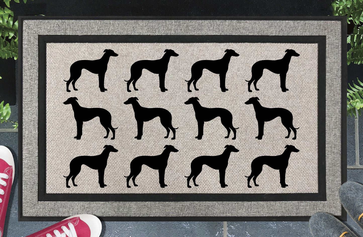 Greyhound Parade all-weather doormat in a doorway setting — rows of Greyhound silhouettes with deep chest, tucked waist, and long elegant legs in a repeating pattern on a woven polyester mat with black border