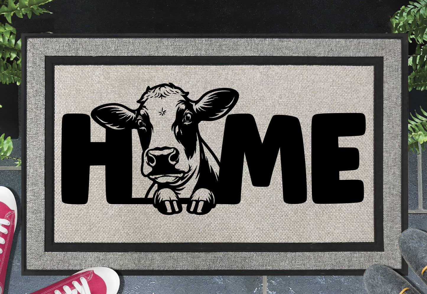 Holstein Cow Doormat #1 all-weather mat with cow peering through HOME lettering on grey woven polyester, placed at front door entryway on dark tile