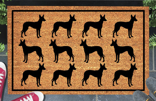 Podenco Parade coir doormat in a doorway setting — rows of Podenco silhouettes with large upright ears and lean athletic frame in a repeating pattern on a natural coir mat with black border