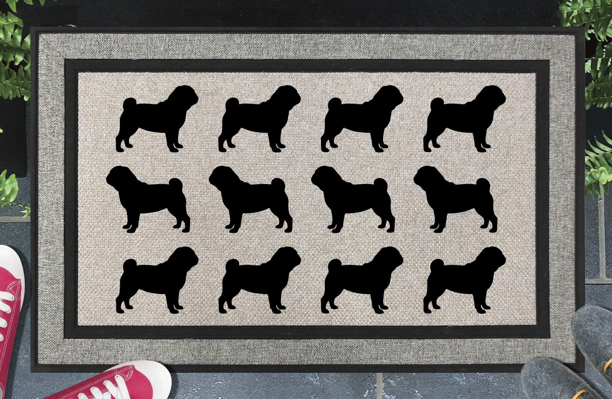 Pug Parade all-weather doormat in a doorway setting — rows of Pug silhouettes with stocky frame, curled tail, and flat wrinkled face in a repeating pattern on a woven polyester mat with black border