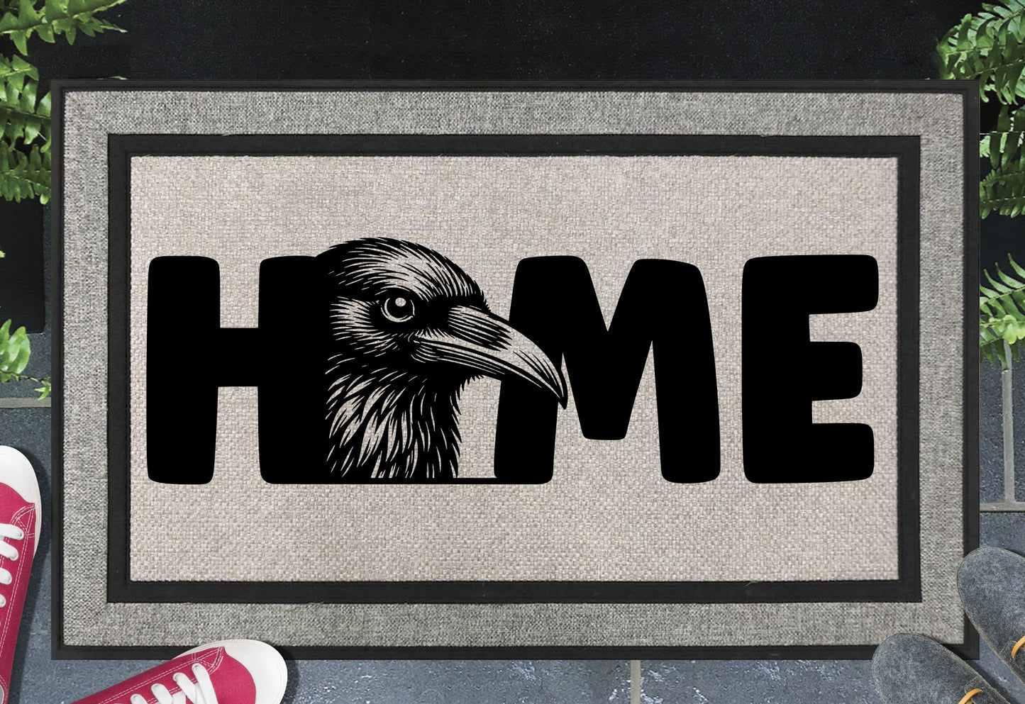 Raven doormat #2 on a front porch entryway — raven head portrait as the O in HOME on a grey woven polyester mat