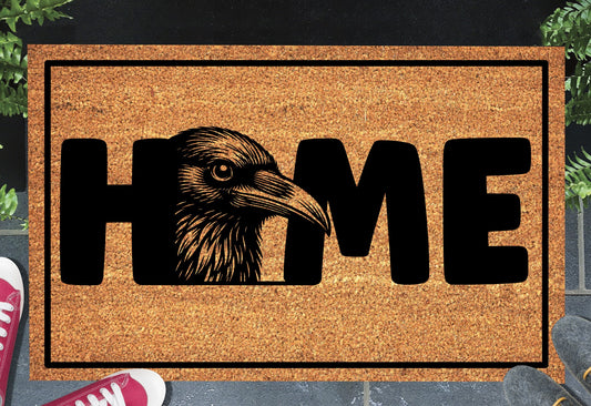 Raven doormat #2 on a front porch entryway — raven head illustration replacing the O in HOME
