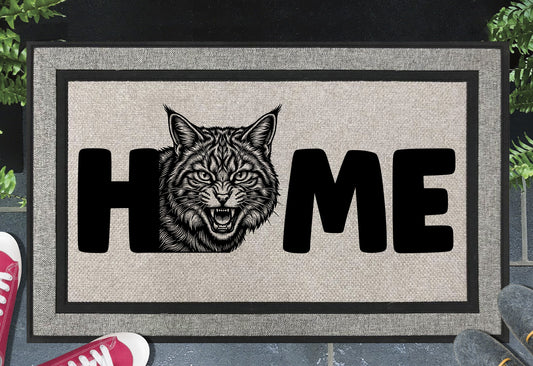 Scottish Wildcat doormat shown at front door, hissing Scottish Wildcat illustration with HOME lettering on grey woven polyester mat