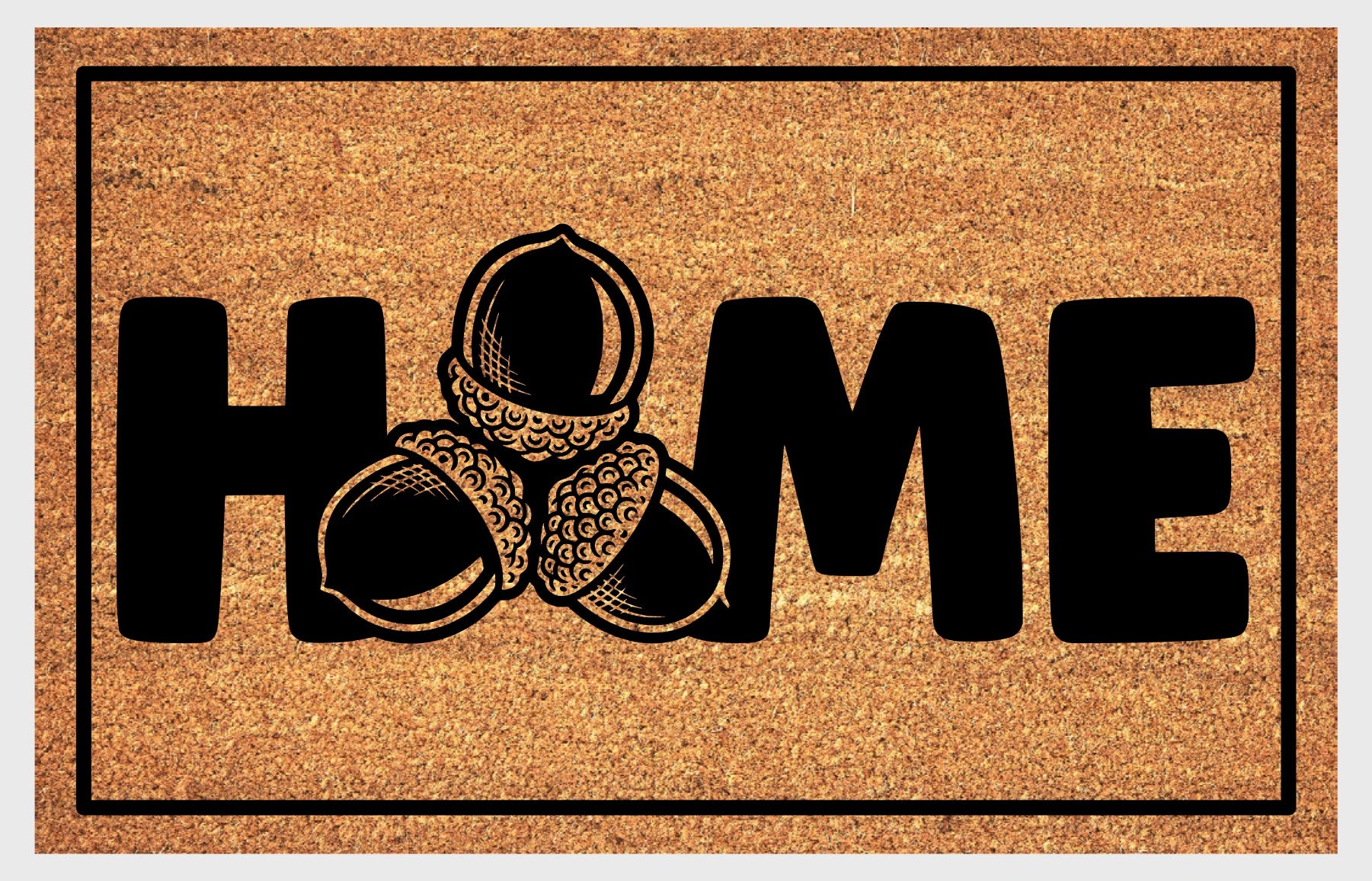 Sessile Oak Welsh Oak acorn coir doormat with bold black HOME lettering and cluster of three acorn illustrations replacing the letter O, on a natural golden coir surface with black border, plain background.