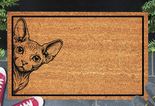 Sphynx cat peeking doormat in a doorway setting — natural coir welcome mat