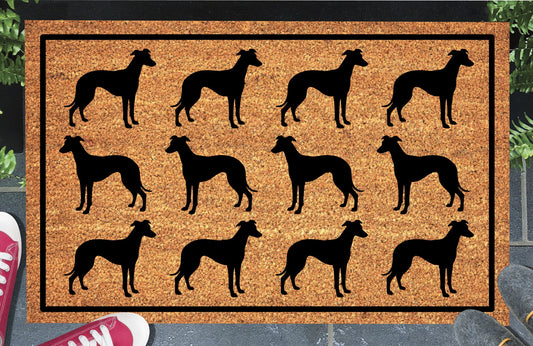 Whippet Parade coir doormat in a doorway setting — rows of Whippet silhouettes with deep chest, tucked waist, and lean aerodynamic frame in a repeating pattern on a natural coir mat with black border
