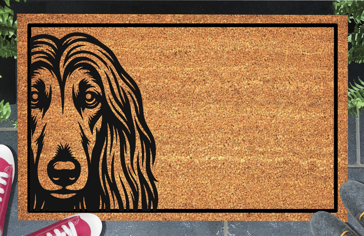 Afghan Hound Peeking Doormat #2 with bold black Affie face artwork peeking from the left edge of a bordered coir mat, shown in a doorway
