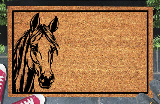 Arabian Horse peeking from the left edge of a natural coir doormat, with upright ears, expressive eyes, a flowing mane and black border, shown at an entryway.