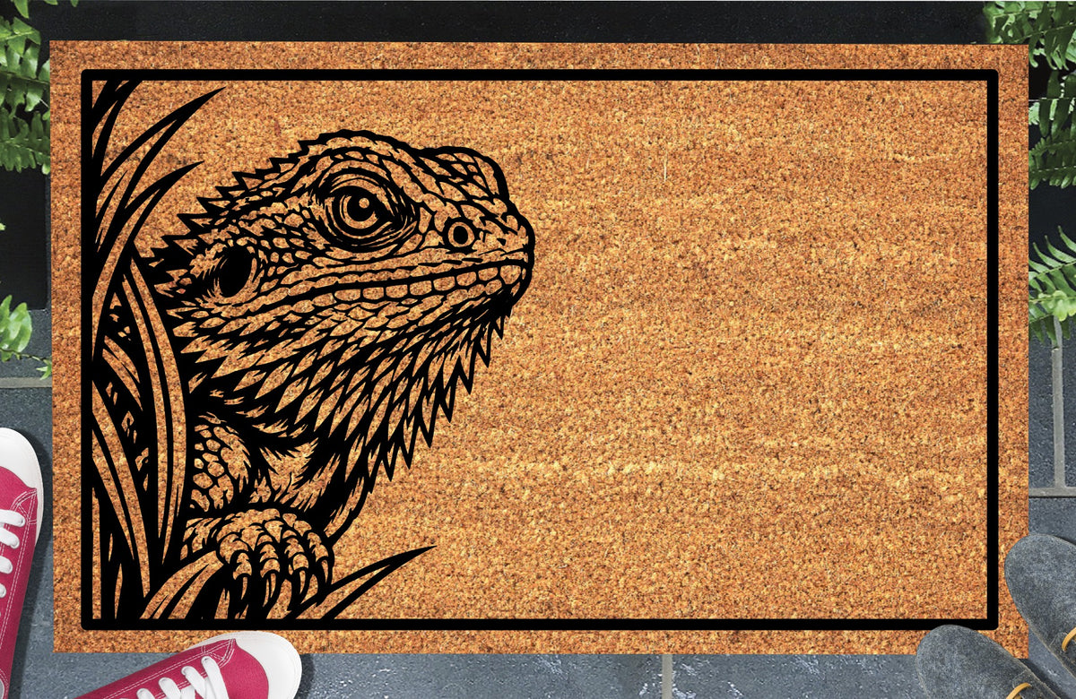 Bearded Dragon Peeking coir doormat with a black Pogona illustration peeking through foliage on the left, shown in a doorway