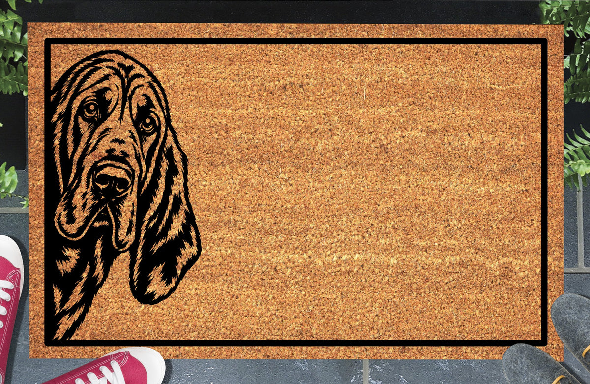 Bloodhound Peeking coir doormat with a long-eared Sleuth Hound illustration peeking from the left and a black border, shown in a doorway