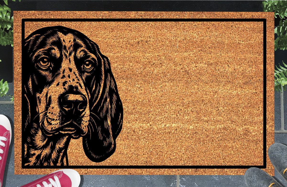 Bluetick Hound Peeking coir doormat with a long-eared Bluetick Coonhound illustration, speckled muzzle and black border, shown in a doorway