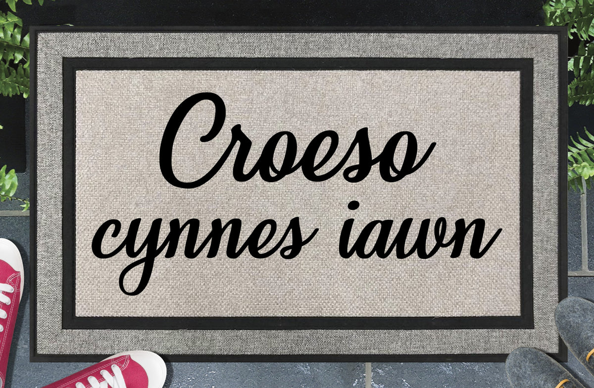 Croeso cynnes iawn all-weather doormat — Welsh very warm welcome in bold lettering, woven polyester, linen-look finish, non-slip backing, 18x30"