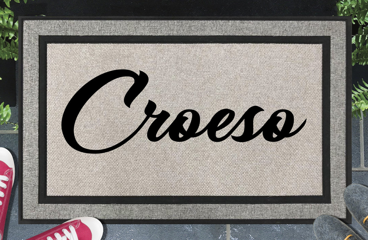 Croeso all-weather doormat — Welsh welcome word in bold script lettering, woven polyester, linen-look finish, non-slip backing, 18x30"