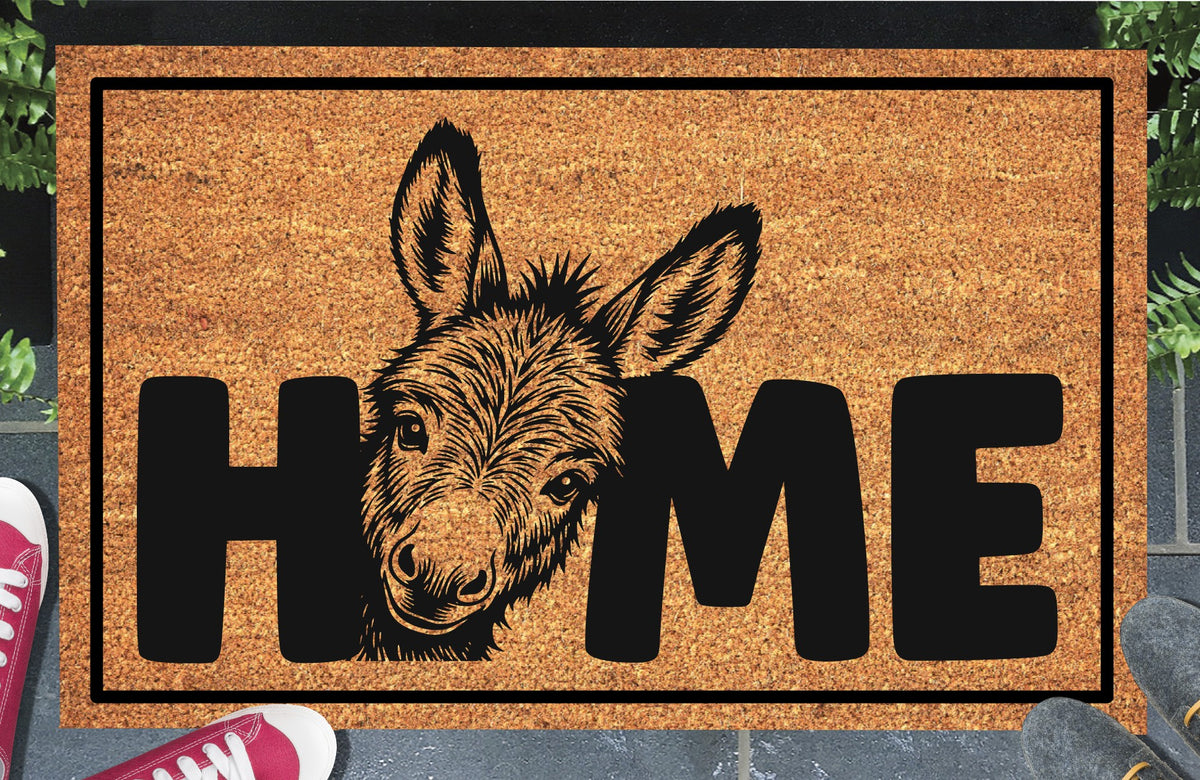 Donkey Doormat #2 Jackass coir doormat — donkey face peeking through the letter O in HOME, natural coir fiber, non-slip rubber backing, flat lay on dark background
