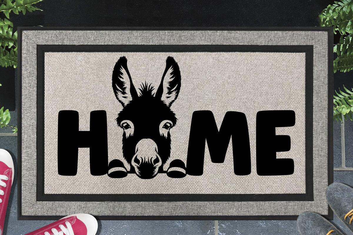 Donkey all-weather doormat — donkey illustration replacing the letter O in HOME, woven polyester, non-slip backing, flat lay 