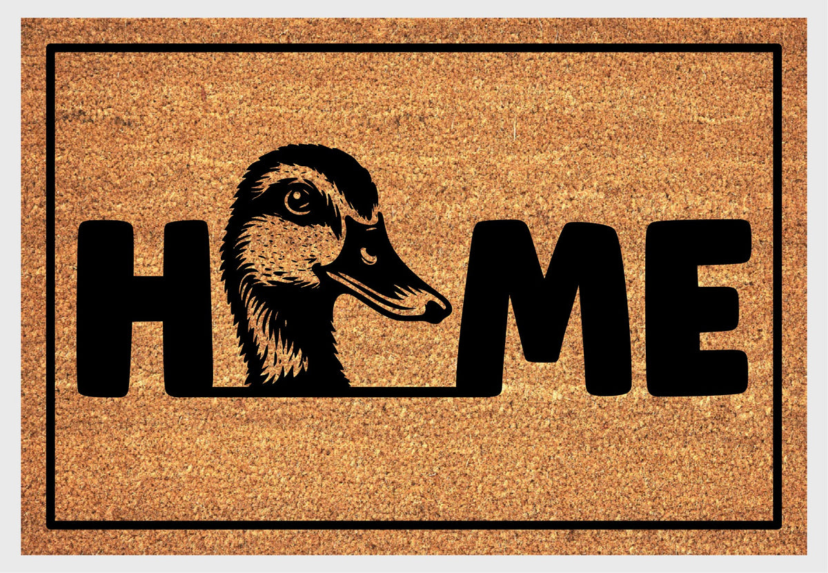 Mallard Welcome Mat coir doormat — close-up of duck head illustration replacing the letter O in HOME on natural coir