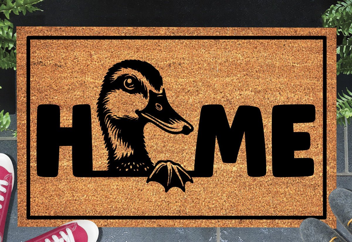 Duck Doormat #2 Quacker Welcome Mat coir doormat — duck illustration replacing the letter O in HOME, natural coir fiber, non-slip rubber backing, flat lay on dark background