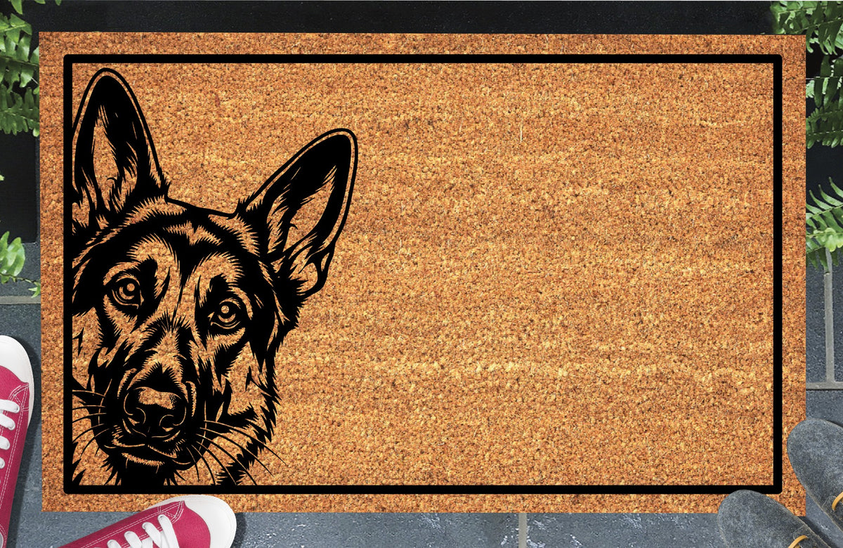German Shepherd Peeking Doormat #1, Alsatian portrait with tall upright ears peeking from the left edge inside a black border on natural coir, styled at an entryway.