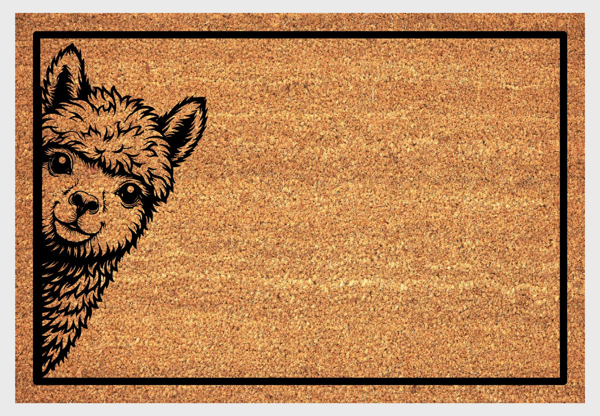 Huacaya Alpaca peeking coir doormat, front view showing upright ears, expressive eyes and a fluffy forelock inside a black rectangular border.