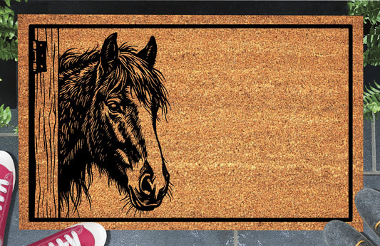 Irish Cob Horse peeking beside a wooden stable door on a natural coir doormat, with a tousled mane, broad facial blaze and black border, shown at an entryway.