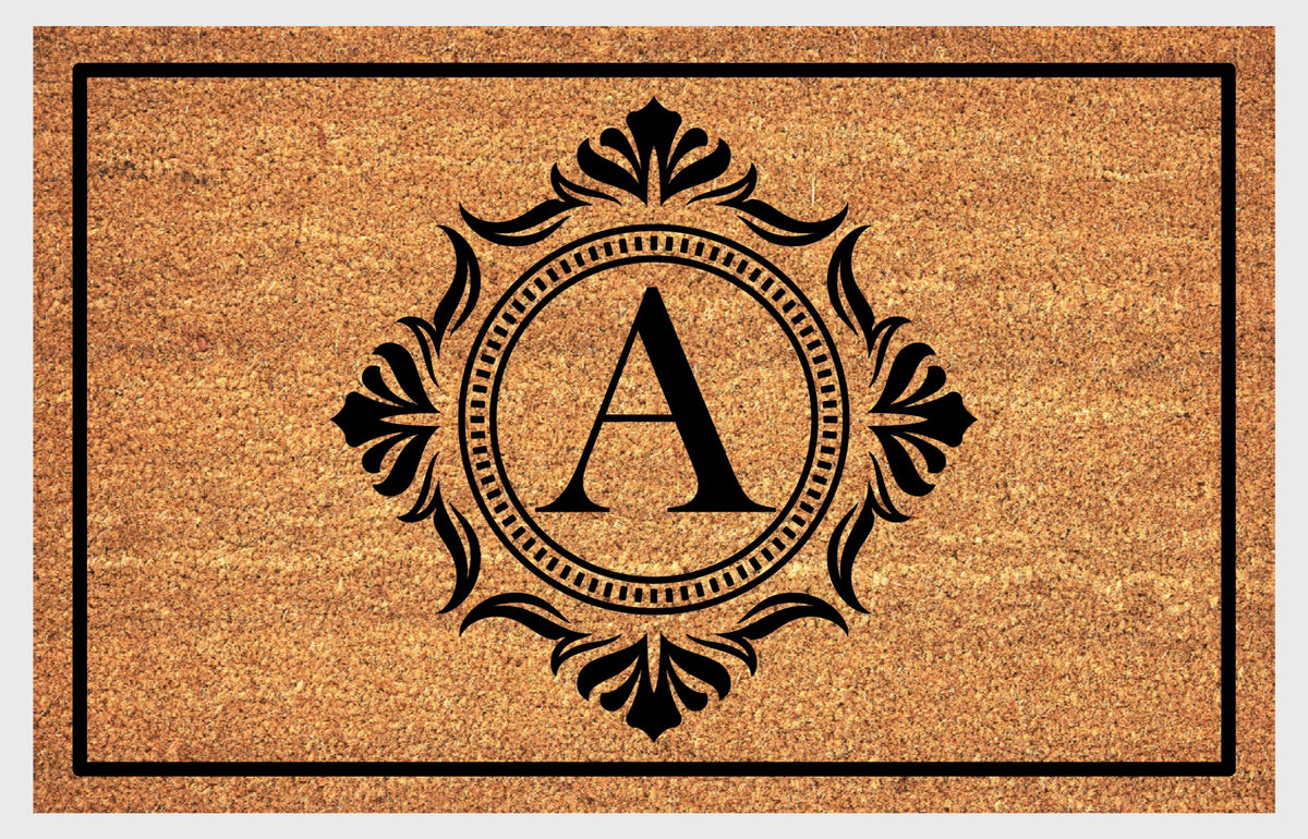 Monogram Letter A doormat in natural coir with an ornate serif letter A in a dotted circular frame, fleur-de-lis style flourishes, and a black border, shown flat.