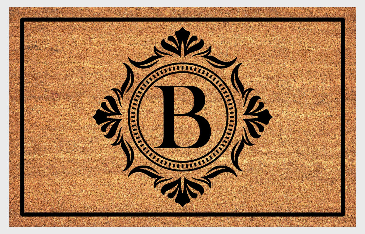Monogram Letter B doormat in natural coir with an ornate serif letter B in a dotted circular frame, fleur-de-lis style flourishes, and a black border, shown flat.