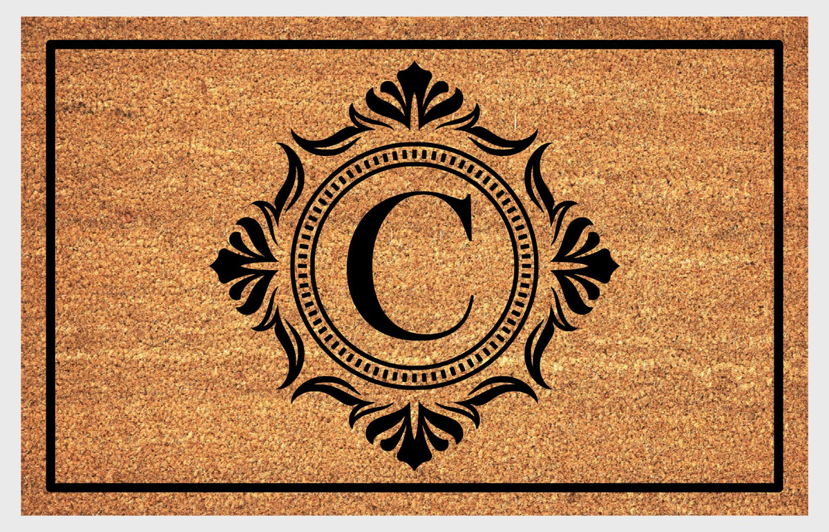 Monogram Letter C doormat in natural coir with an ornate serif letter C in a dotted circular frame, fleur-de-lis style flourishes, and a black border, shown flat.
