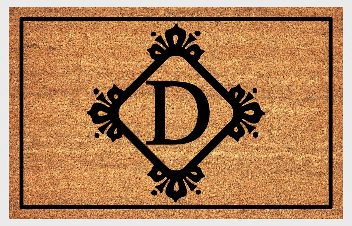 Monogram Letter D doormat in natural coir with an ornate serif letter D in a diamond frame with fleur-de-lis style flourishes and dot accents, with a black border, shown flat.
