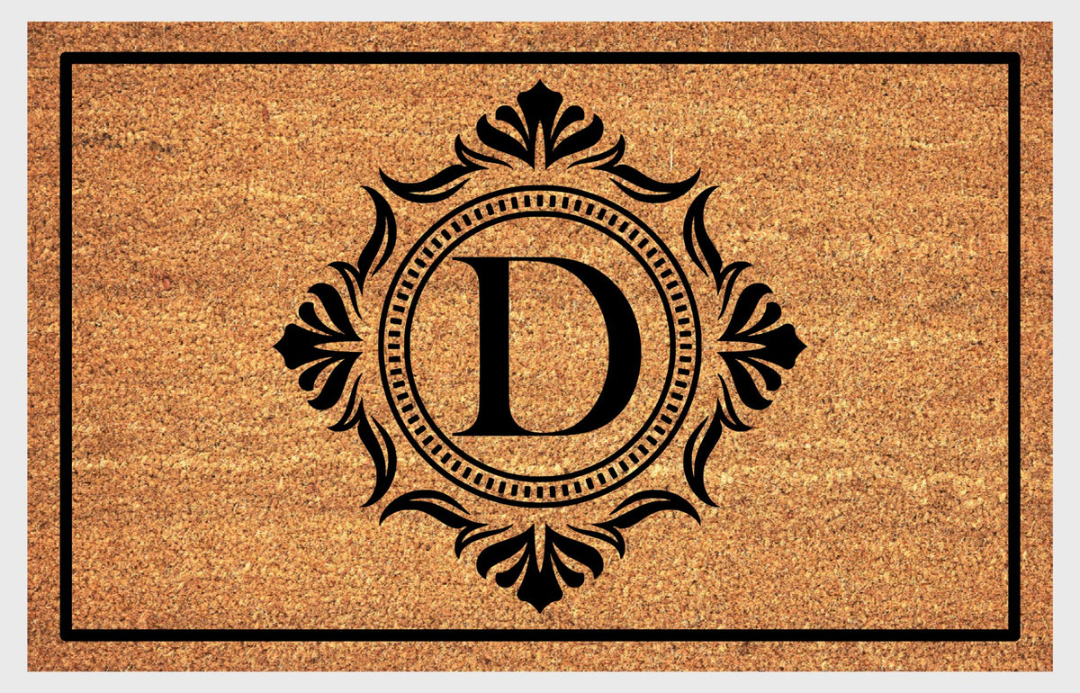 Monogram Letter D doormat in natural coir with an ornate serif letter D in a dotted circular frame, fleur-de-lis style flourishes, and a black border, shown flat.