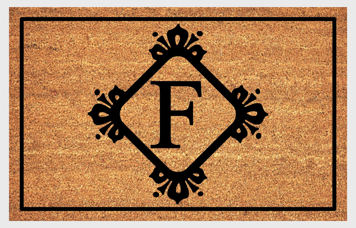 Monogram Letter F doormat in natural coir, featuring a serif F in a diamond frame with fleur-de-lis style flourishes, dot accents and a black border, shown flat.