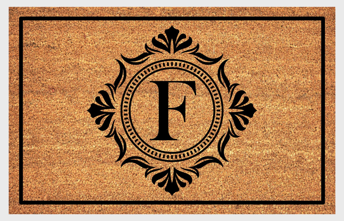 Monogram Letter F doormat in natural coir with an ornate serif letter F in a dotted circular frame, fleur-de-lis style flourishes, and a black border, shown flat.