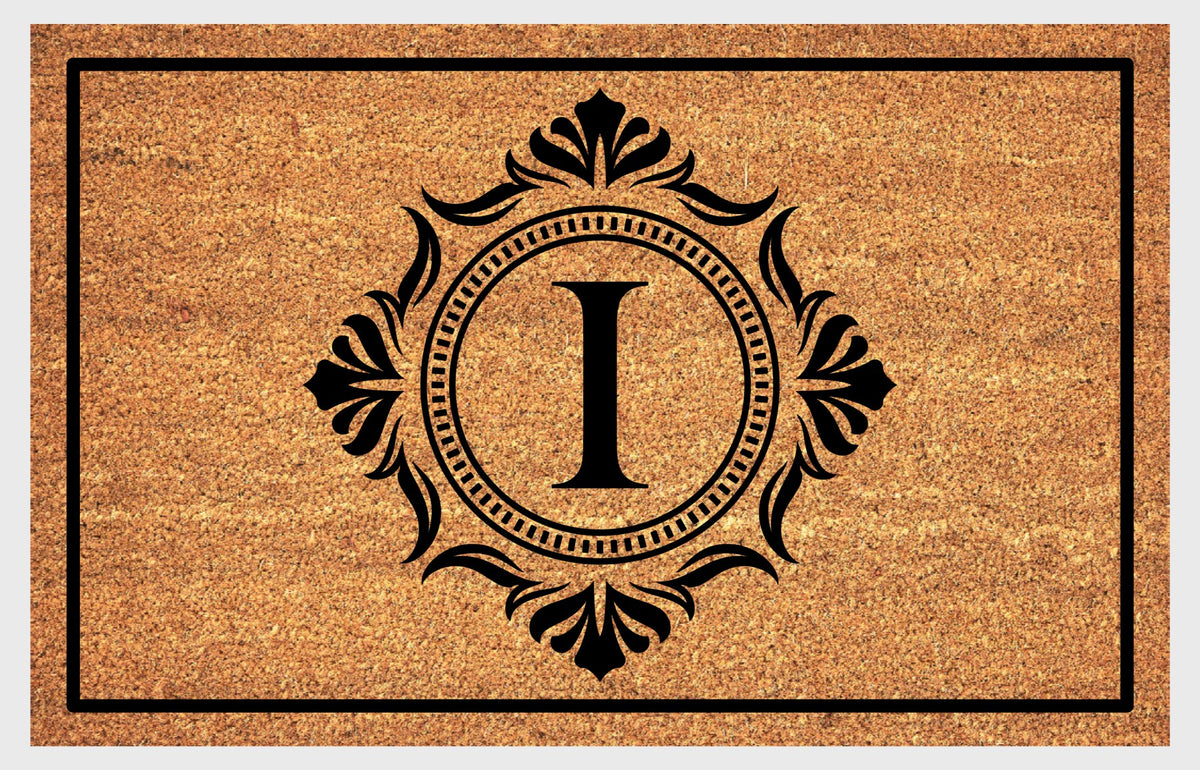 Monogram Letter I doormat in natural coir with an ornate serif letter I in a dotted circular frame, fleur-de-lis style flourishes, and a black border, shown flat.